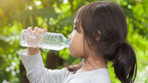 Young girl drinking water because she is thirsty